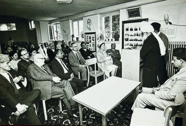 A reception in a hall with guests seated around tables.